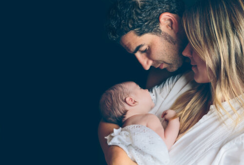 mama y papa con bebe recien nacido en brazos