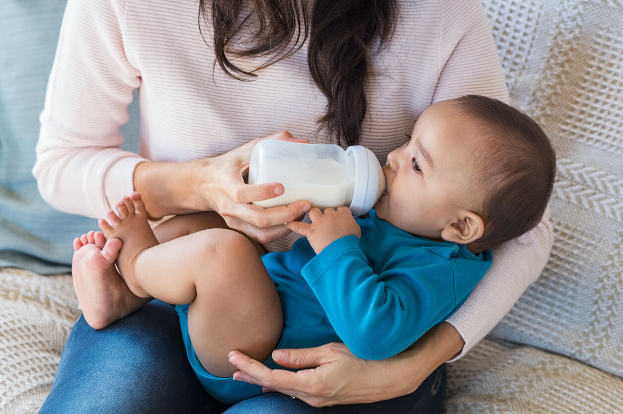 Mère donnant un biberon à son fils.