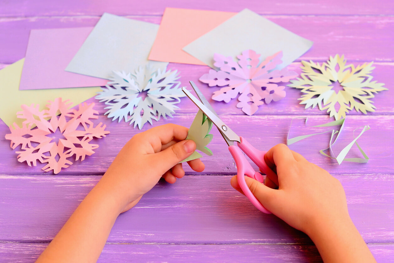 A child making paper snowflakes.
