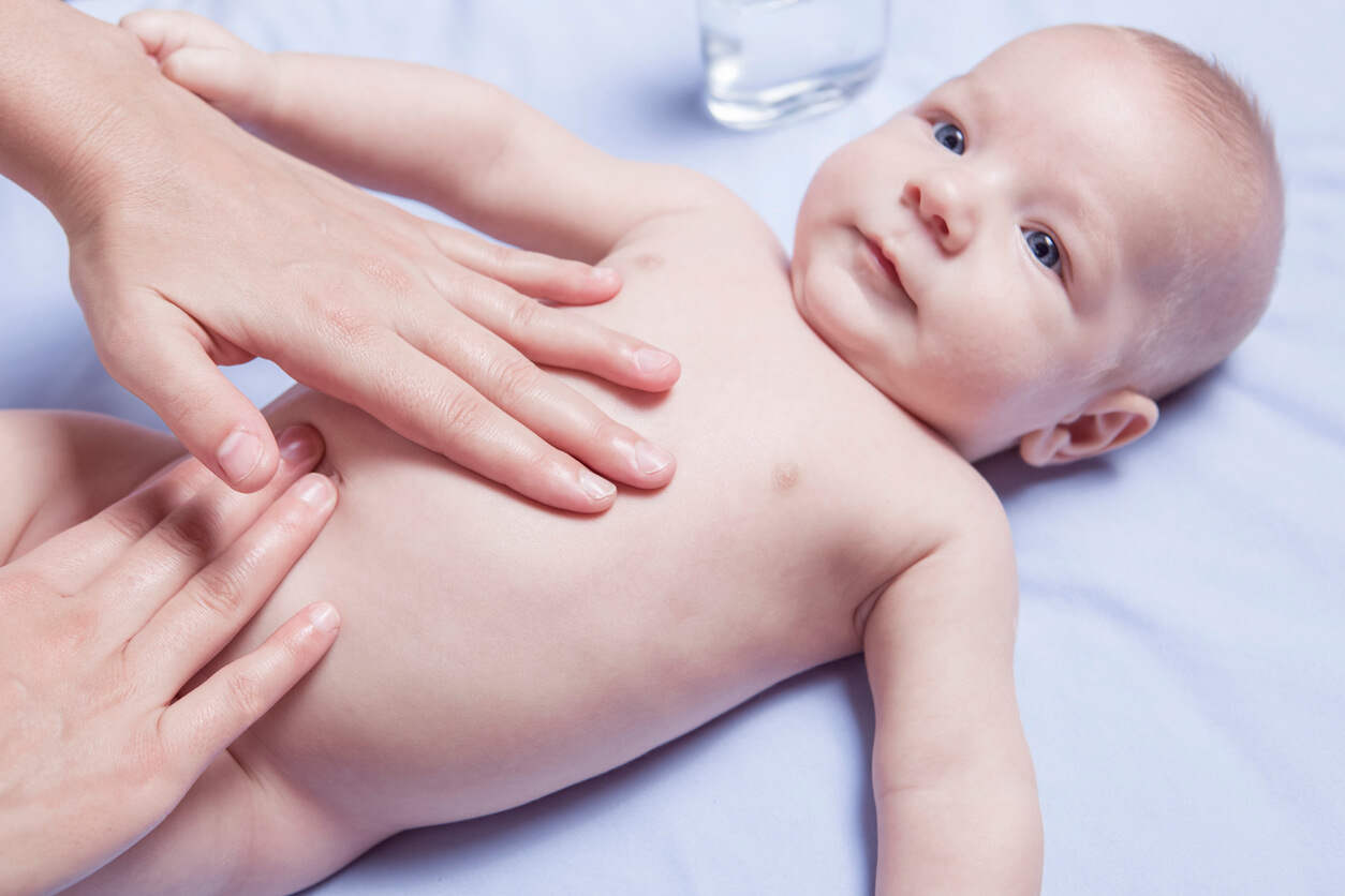 Madre che fa un massaggio a suo figlio per aiutare il bambino a espellere i gas.