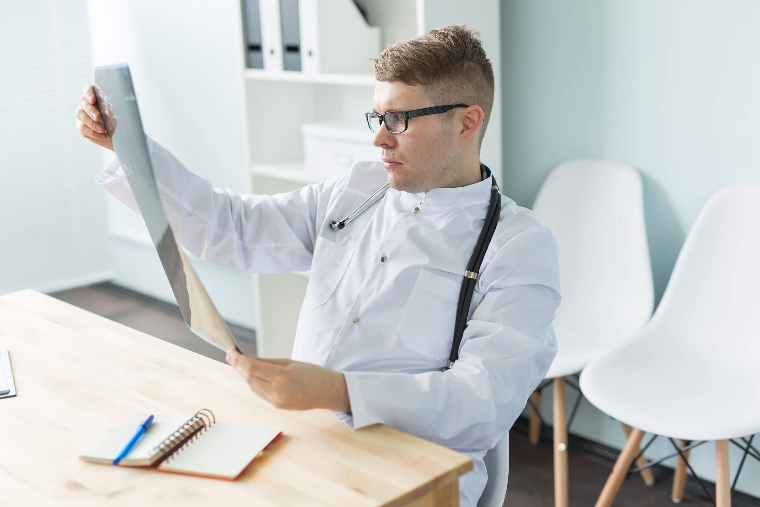 Een arts bekijkt een röntgenfoto van een zondagsarmpje