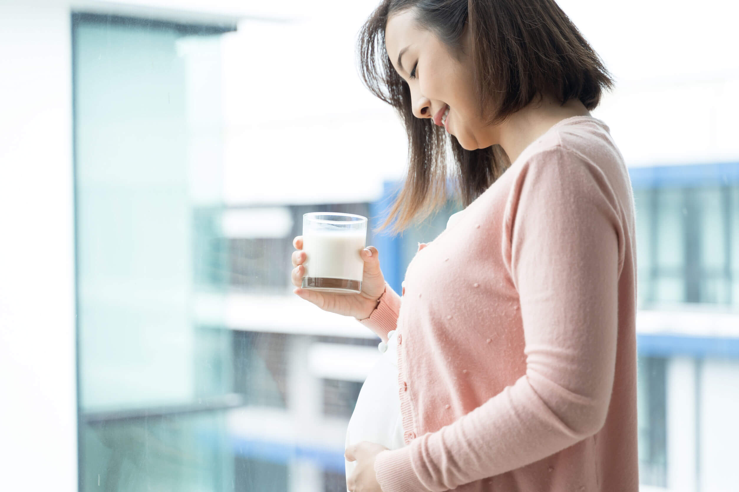 Mujer embarazada bebiendo leche para reducir los ardores estomacales.