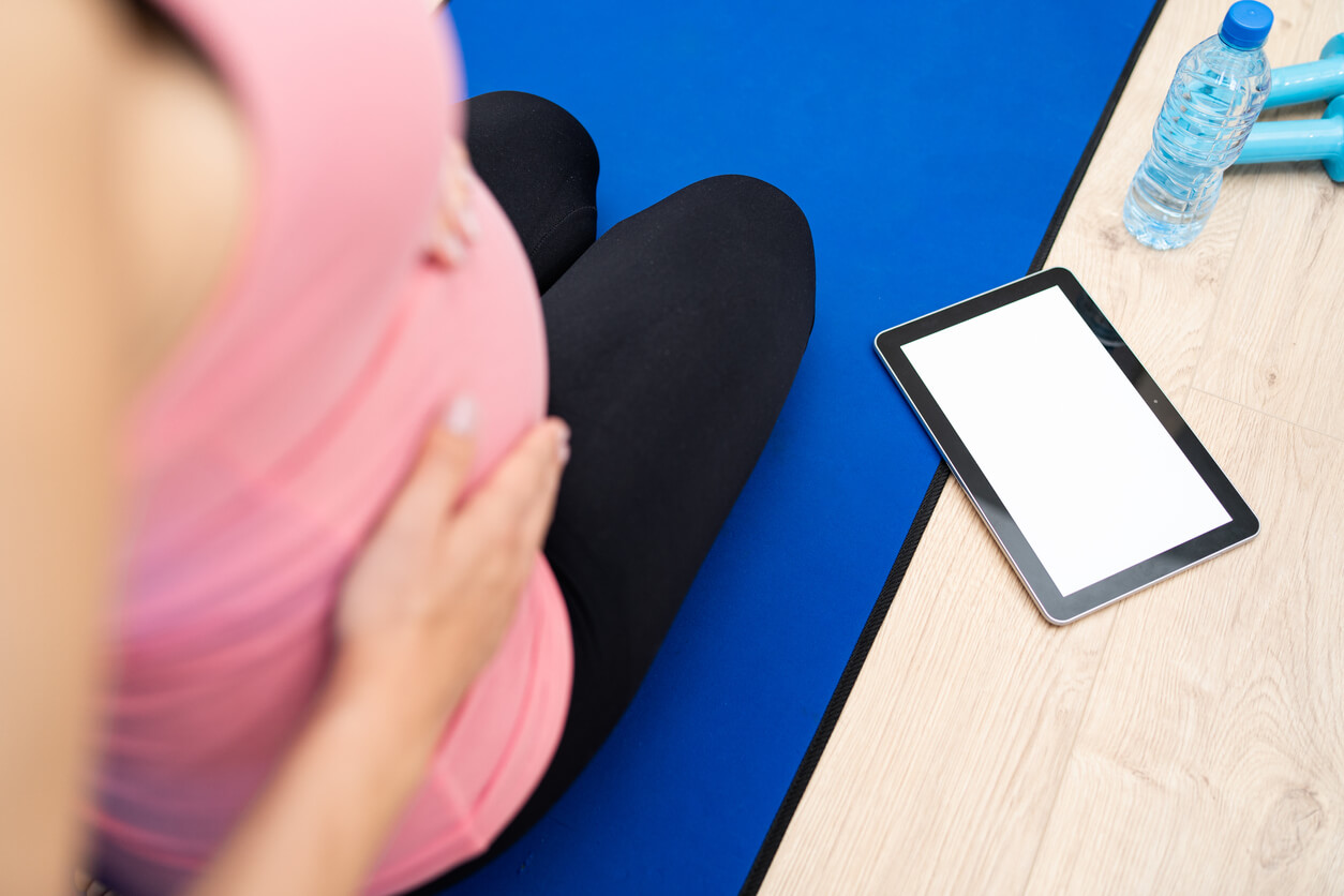 Mujer usando apps para ponerse en forma durante el embarazo.