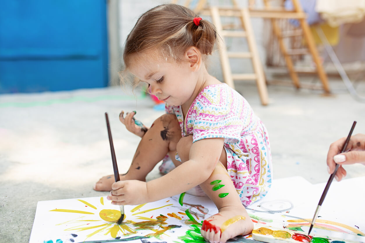 Bambina che dipinge ed esplora la sua creatività.