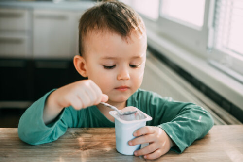 Niño comiendo yogur para aliviar el estreñimiento.