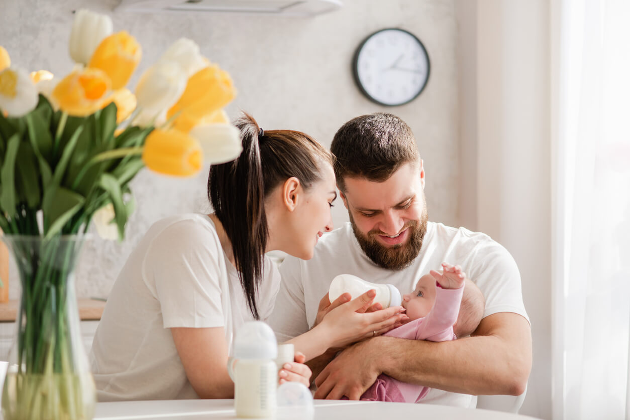 Padres dándole el biberón anticólicos a su bebé.