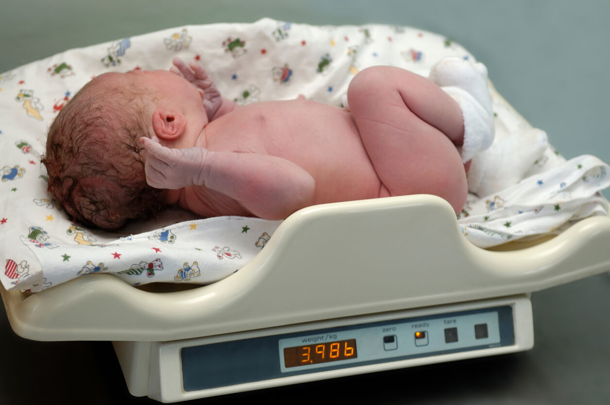 Bebé recién nacido en una báscula para calcular medicación
