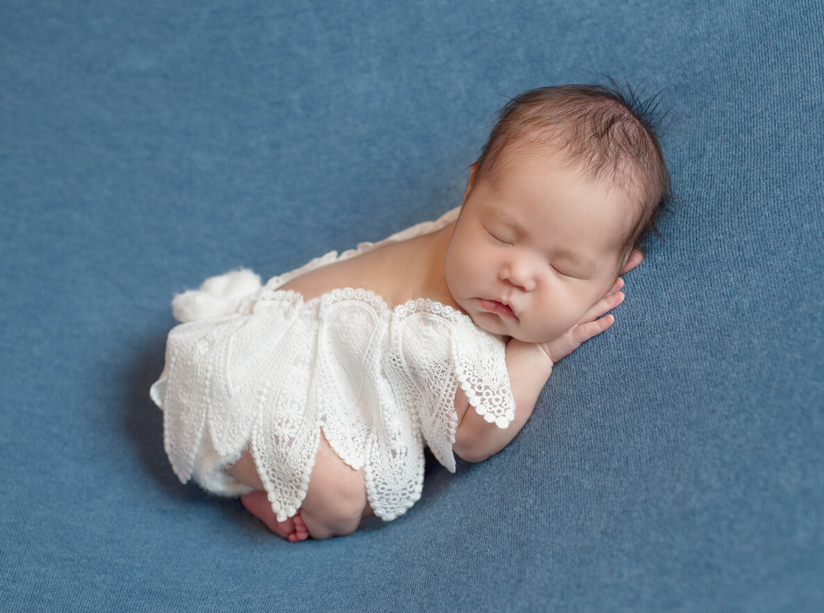 A newborn baby wearing angel wings.