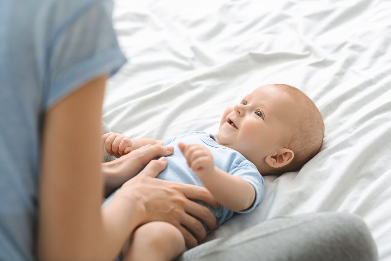 Une mère qui masse son bébé.