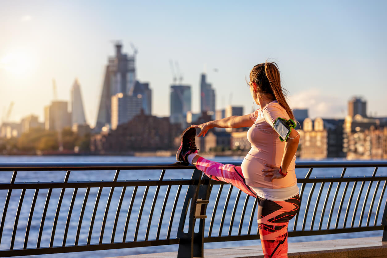 En gravid kvinna som stretchar för träning.