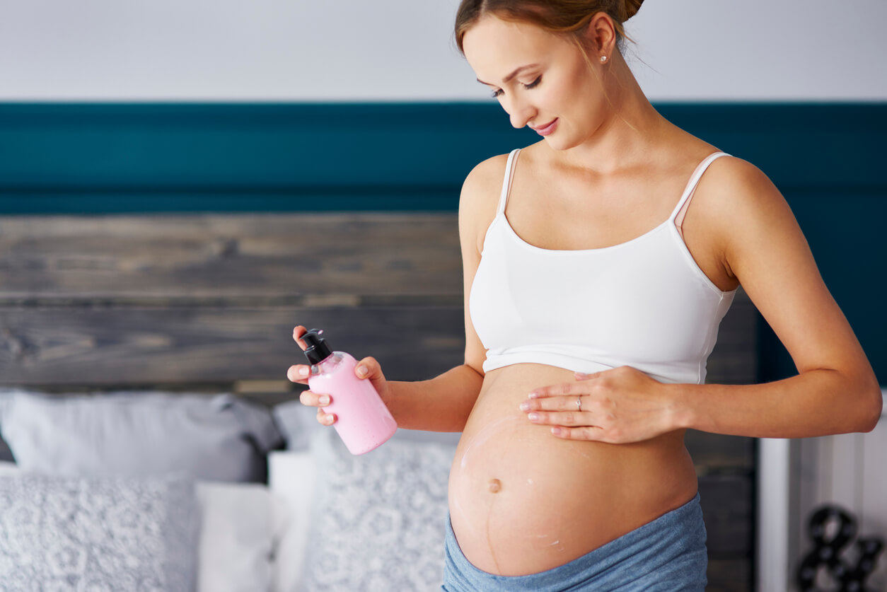 En gravid kvinna som applicerar fuktkräm för att minska uppkomsten av bristningar under graviditeten.