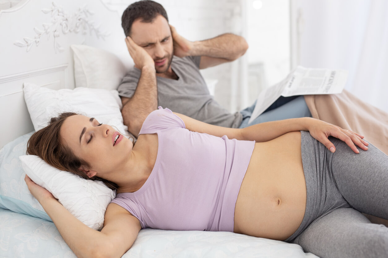 Mujer con ronquidos en el embarazo molestando a su pareja.