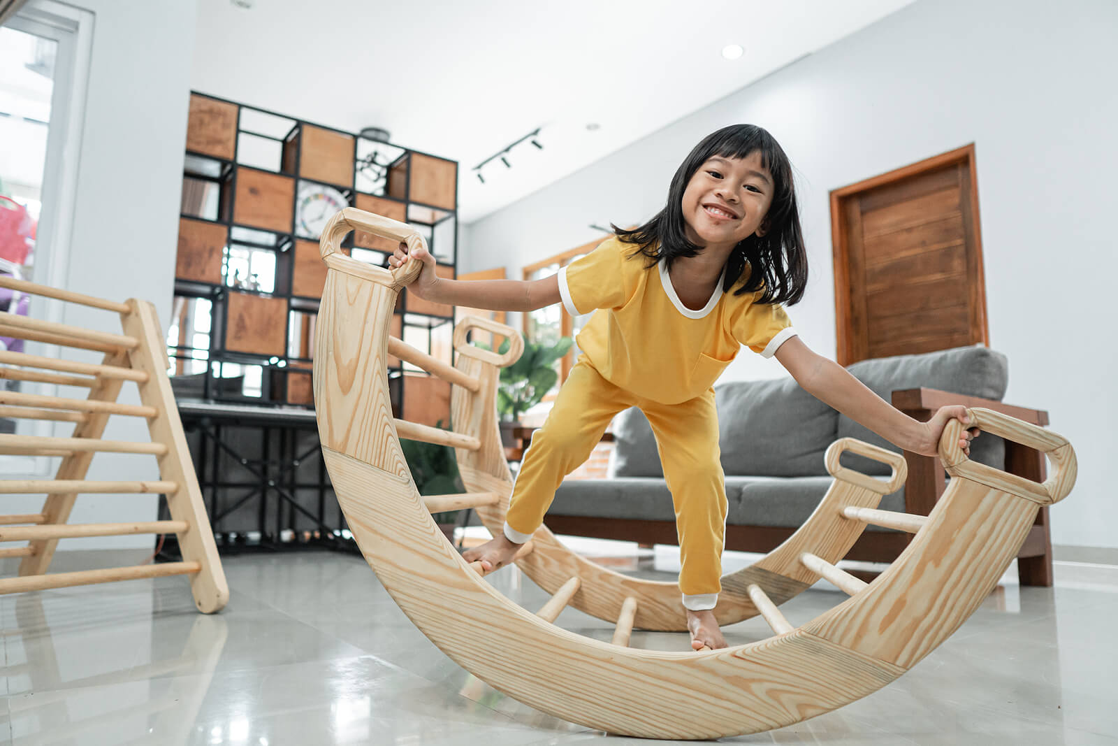 Niña jugando con elementos del método Pikler.