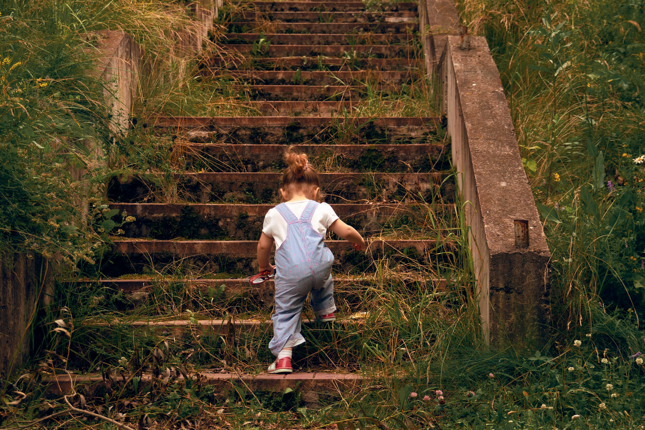Une petite fille qui monte des grands escaliers. 