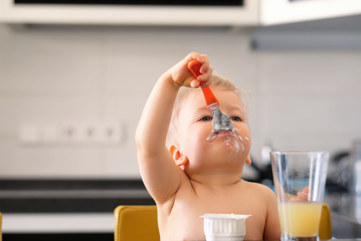 Bébé de 12 mois qui mange un yaourt.