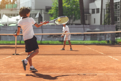 Niño jugando al tenis.