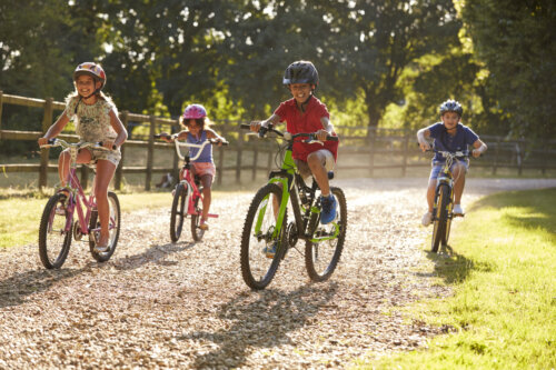 Niños practicando ciclismo al aire libre, uno de los mejores deportes para niños con TDAH.