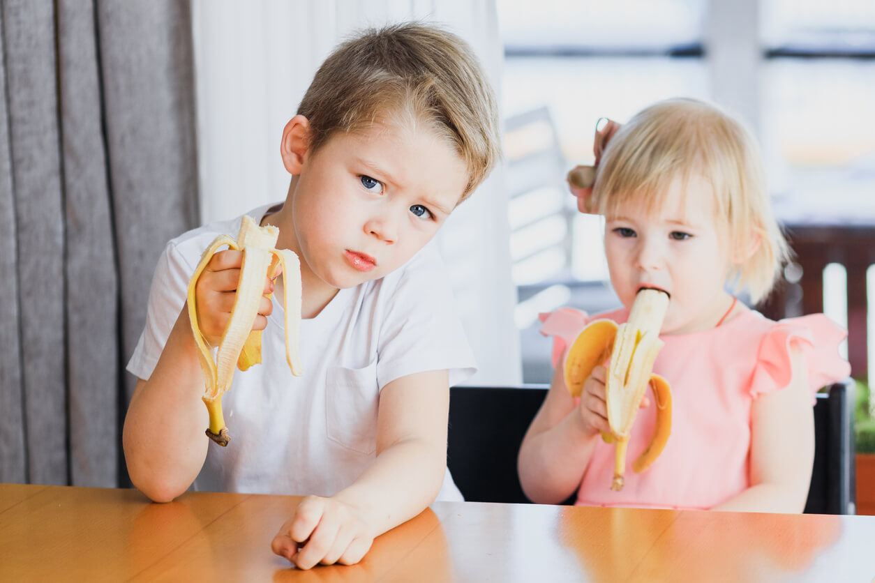 Niños comiendo un plátano cada uno.