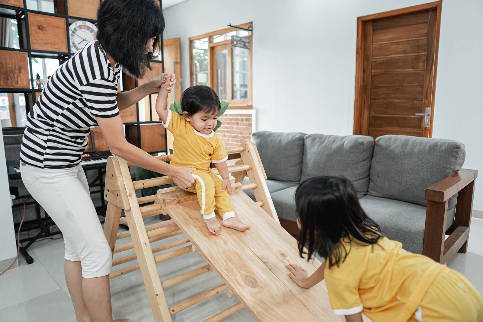 Madre con sus hijos aplicando el método Pikler para promover el movimiento libre en bebés.