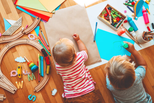 ninos pequenos hacen manualidades en el piso de la casa