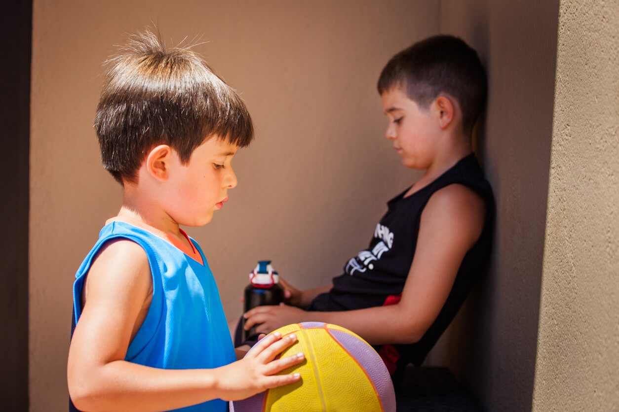 Deux enfants démotivés avec un ballon. 