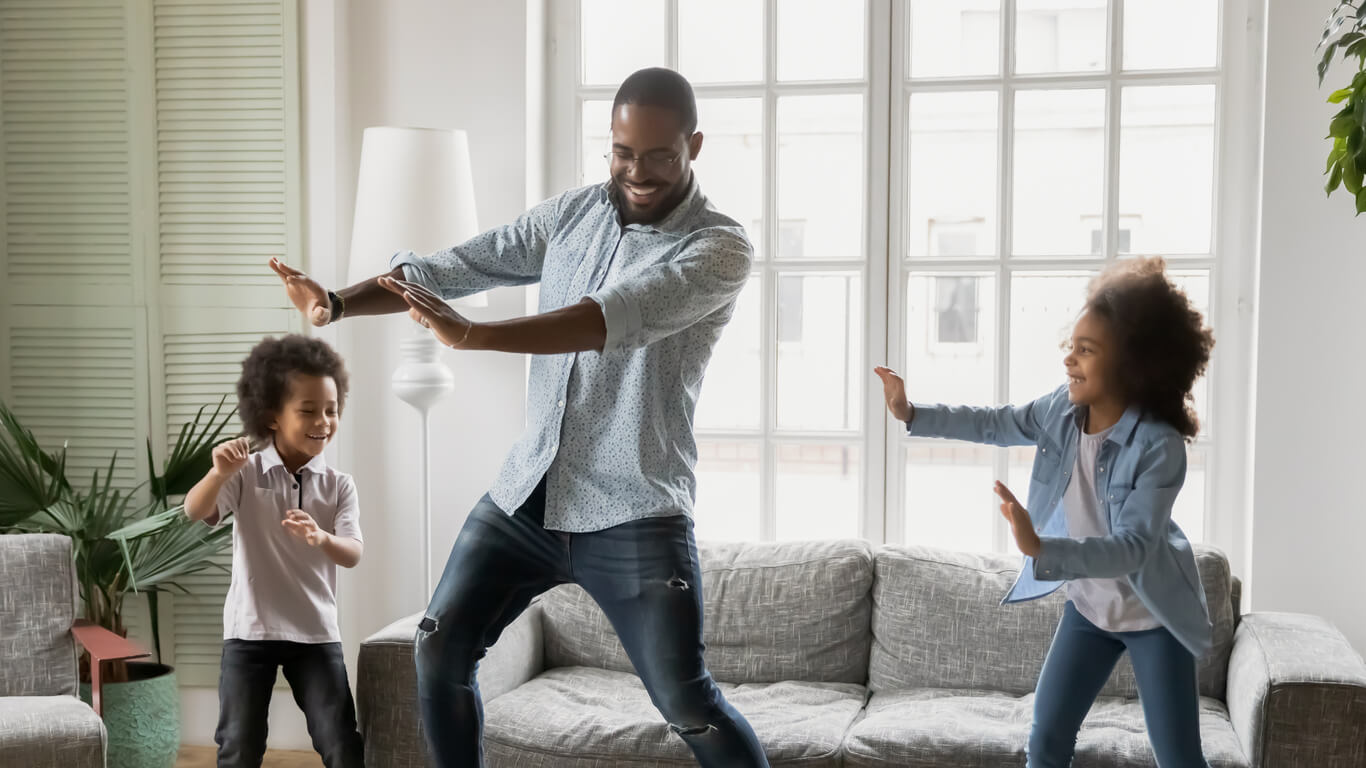 Père dansant avec ses enfants.