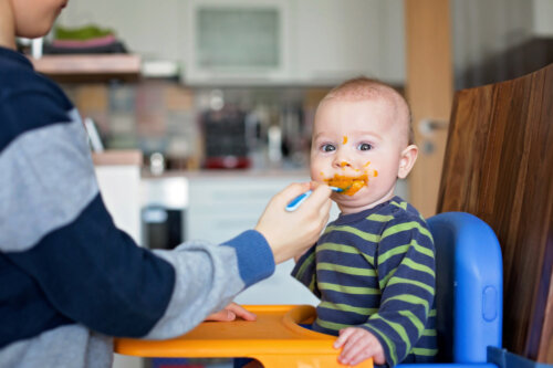 Padre dando de comer a su bebé un puré.