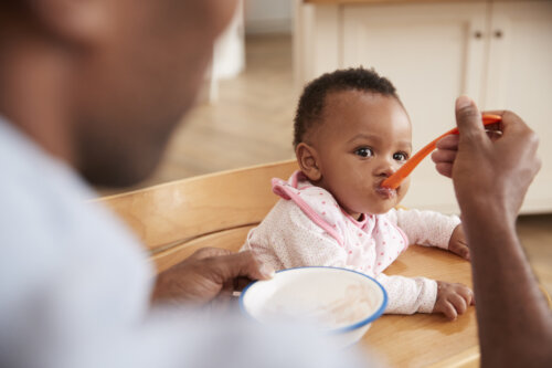 Padre dando de comer a su hijo.