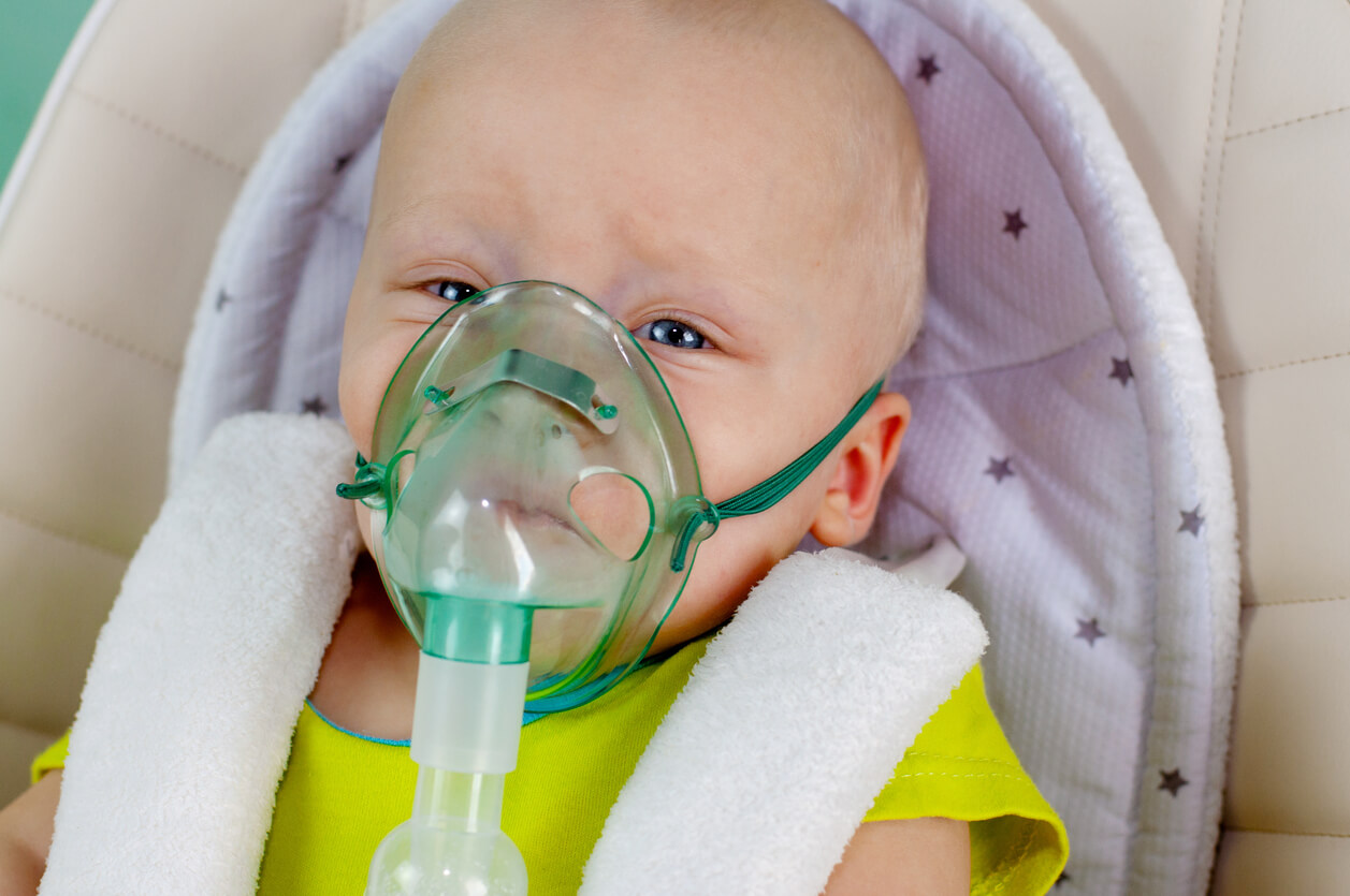 Bébé avec un aérosol sur le visage.
