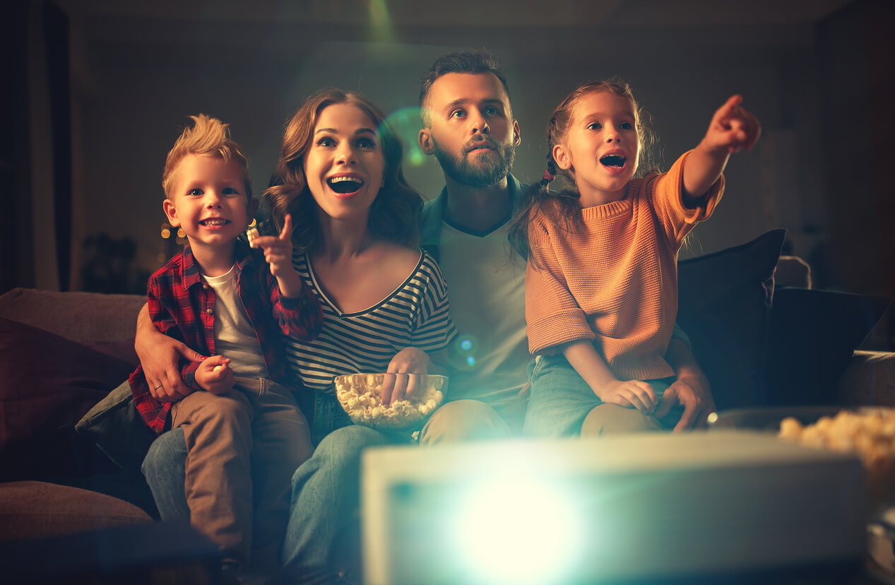 Familia viendo una película para crear momentos felices.
