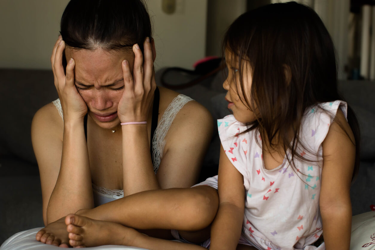 Madre llorando frente a su hija porque padece depresión.