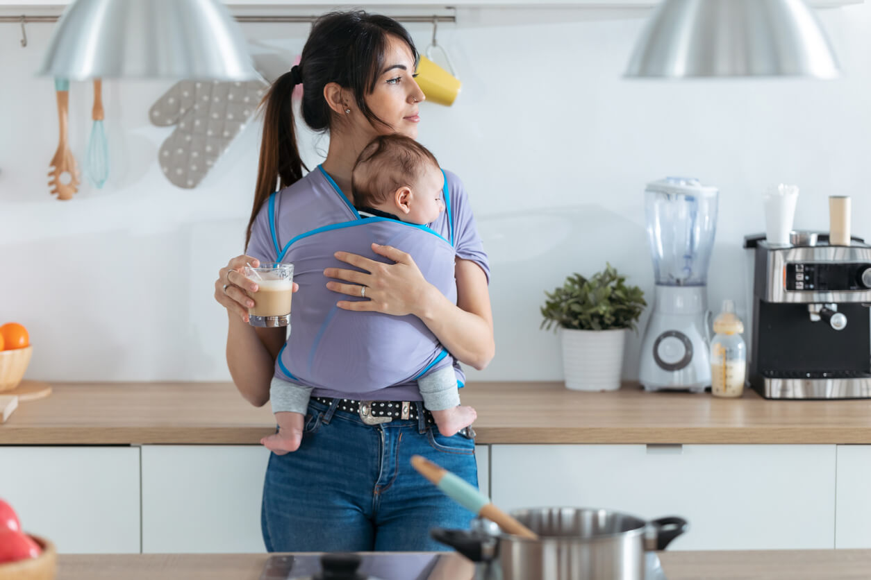 Mère de boire du café avec un bébé dans ses bras pour perdre du poids après l'accouchement.