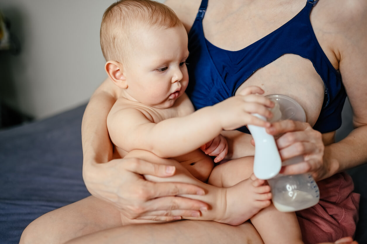 Mamá con su bebé usando uno de los extractores de leche que tiene.