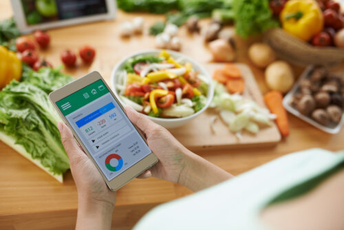 Mujer usando algunas apps de nutrición infantil para que sus hijos lleven una alimentación saludable.