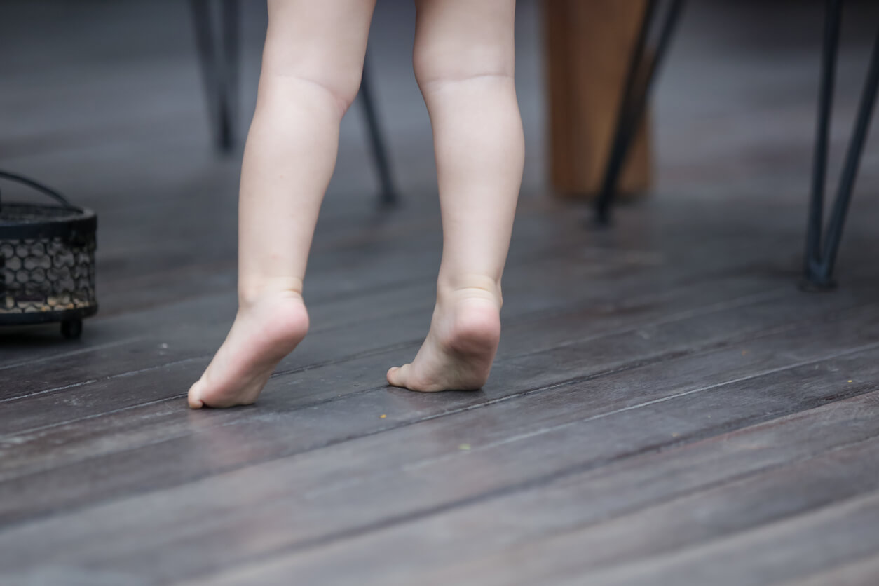 Enfant qui marche sur la pointe des pieds.