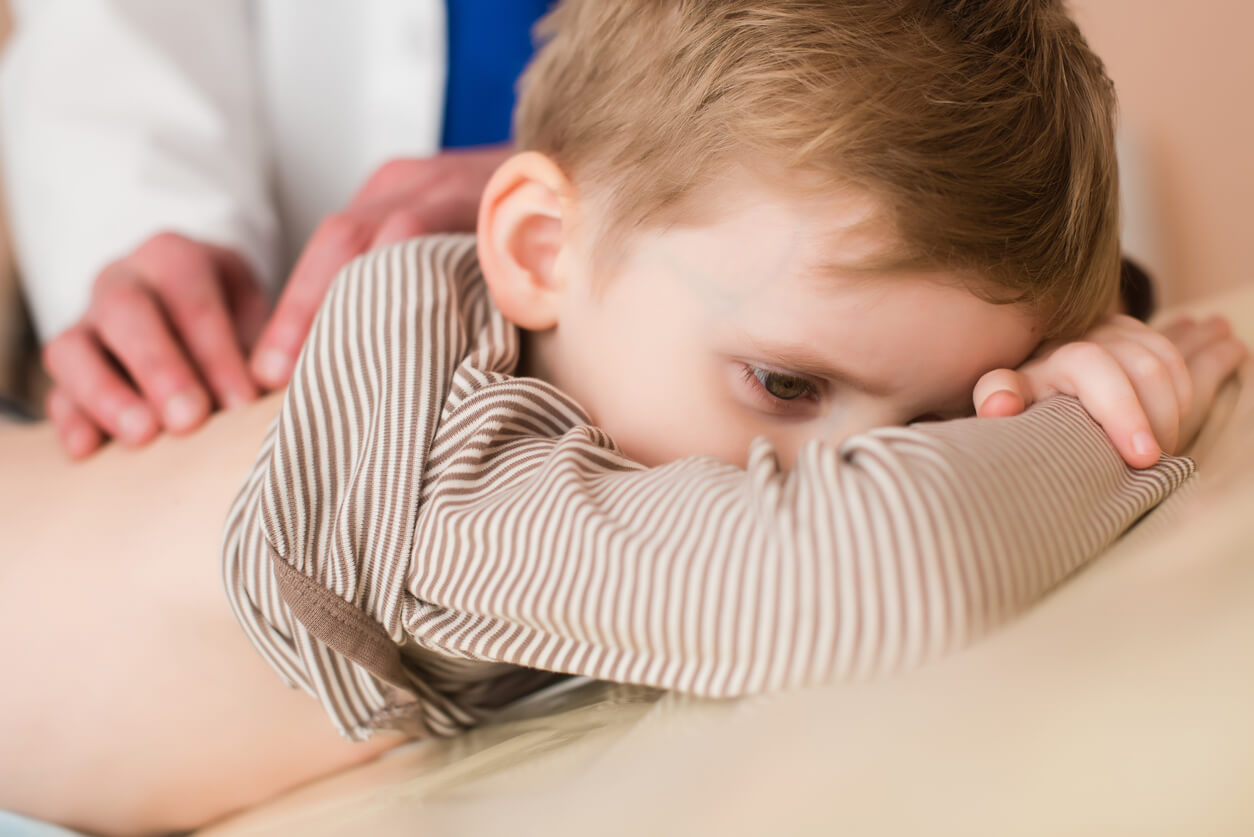 Niño en el médico con dolor de espalda.