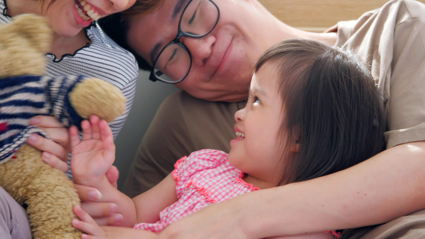 Parents playing with their autistic daughter.