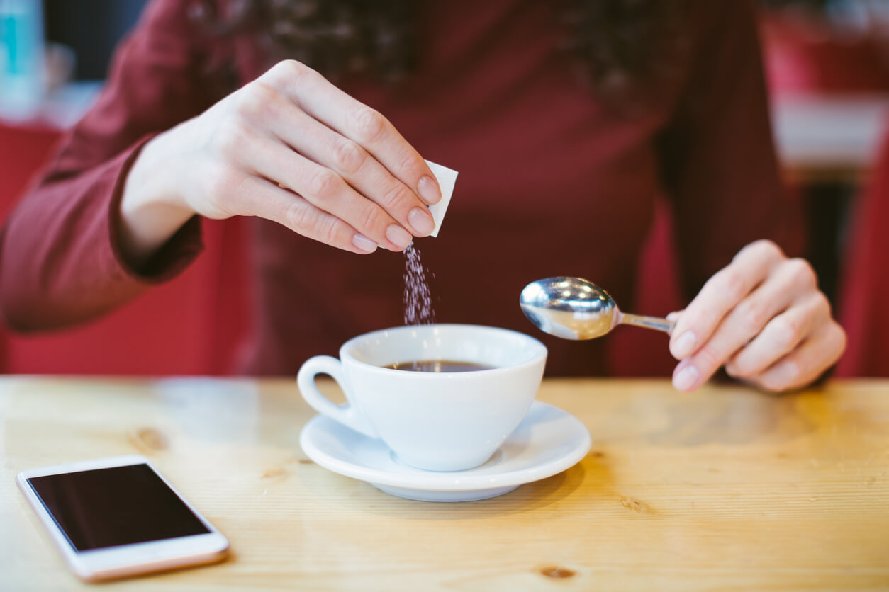 Mujer embarazada usando stevia en su té.