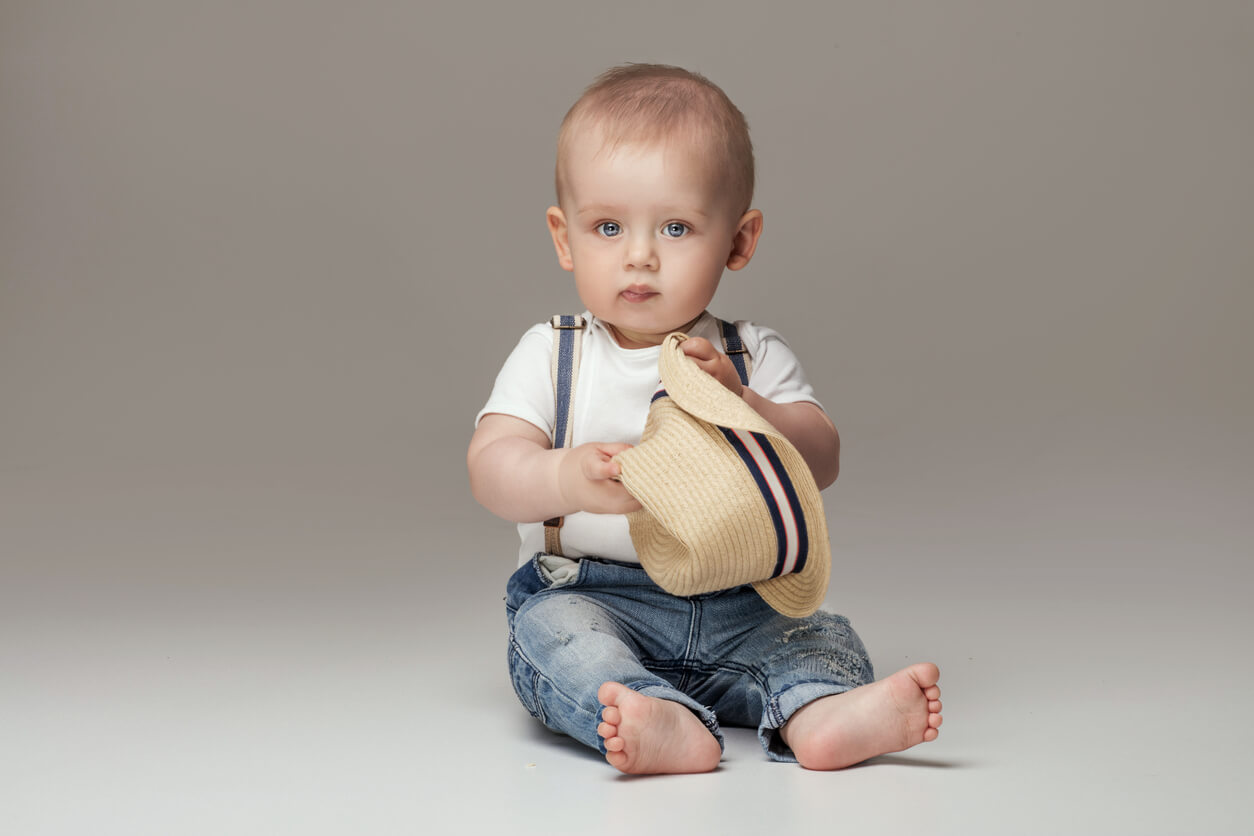 bébé pose avec une barboteuse et un bonnet
