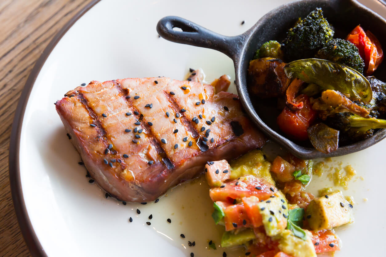 Une assiette avec du thon et des légumes.