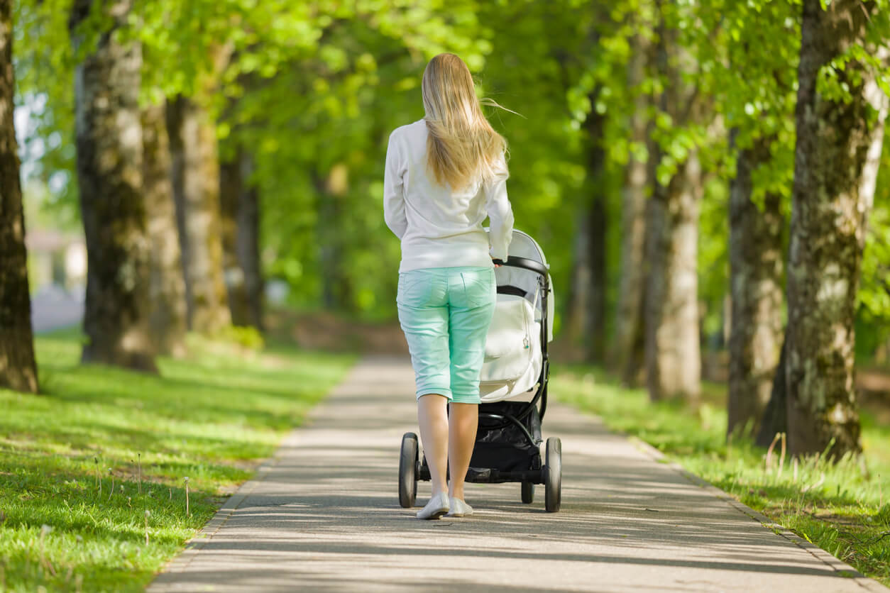 Madre dando un paseo con su bebé por el parque.