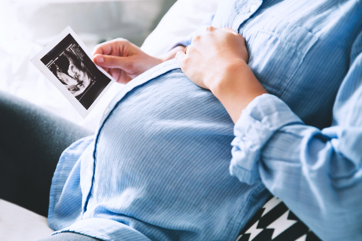 En gravid kvinna tittar på en ultraljudsbild.