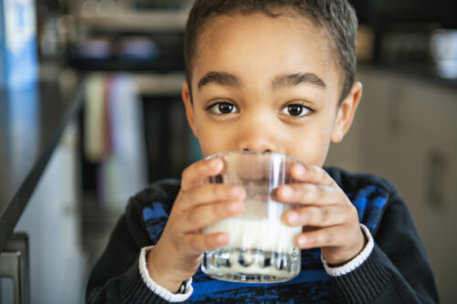 Niño bebiendo un vaso de leche.