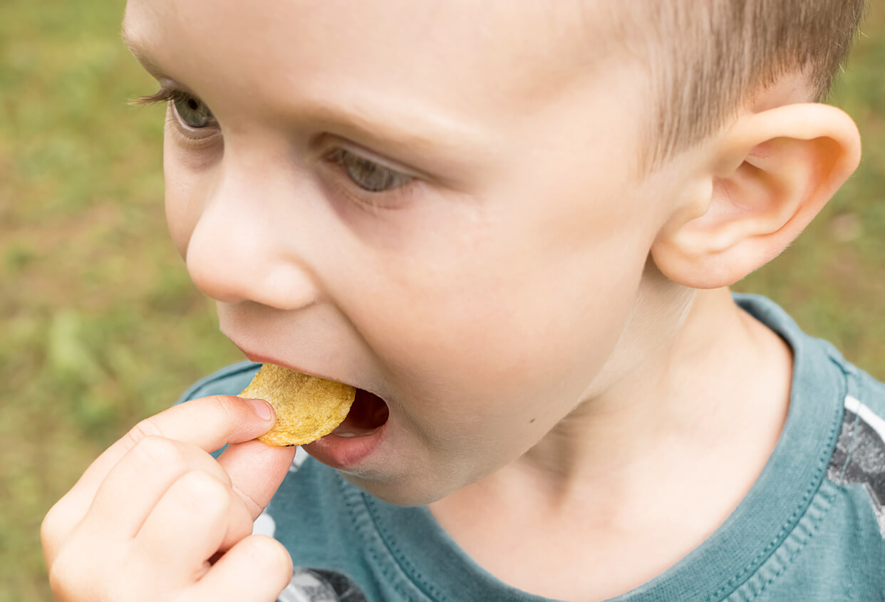 Enfant mangeant des chips avec trop de sel.