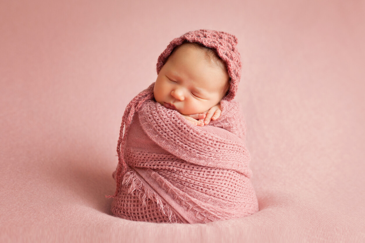 Un bébé enroulé dans une couverture.