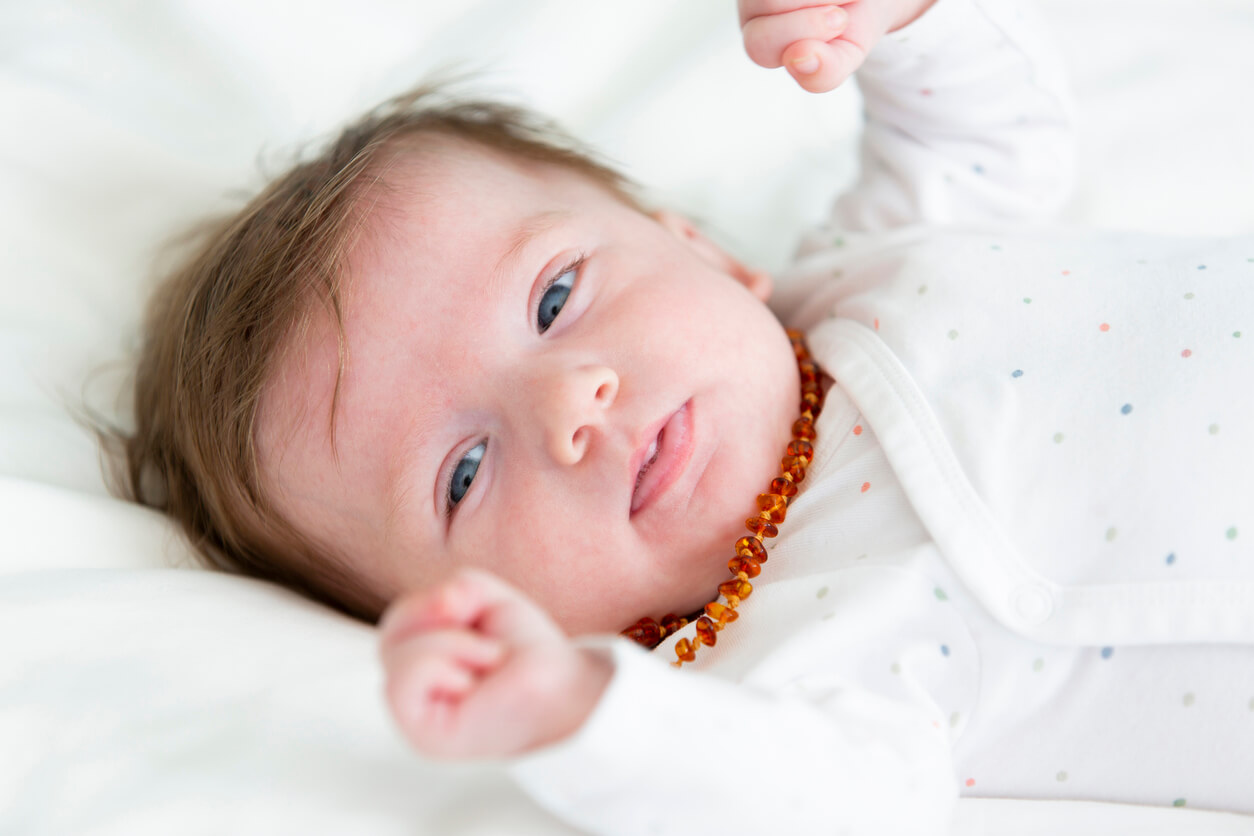 Un bébé avec un collier d'ambre autour du cou. 