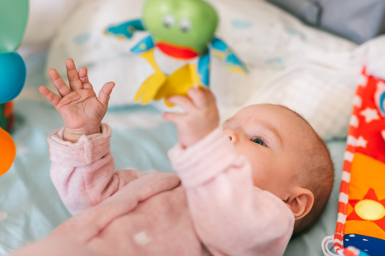 bébé couché couché sur le dos jouet suspendu mobile berceau saisit la main prendre éveillé