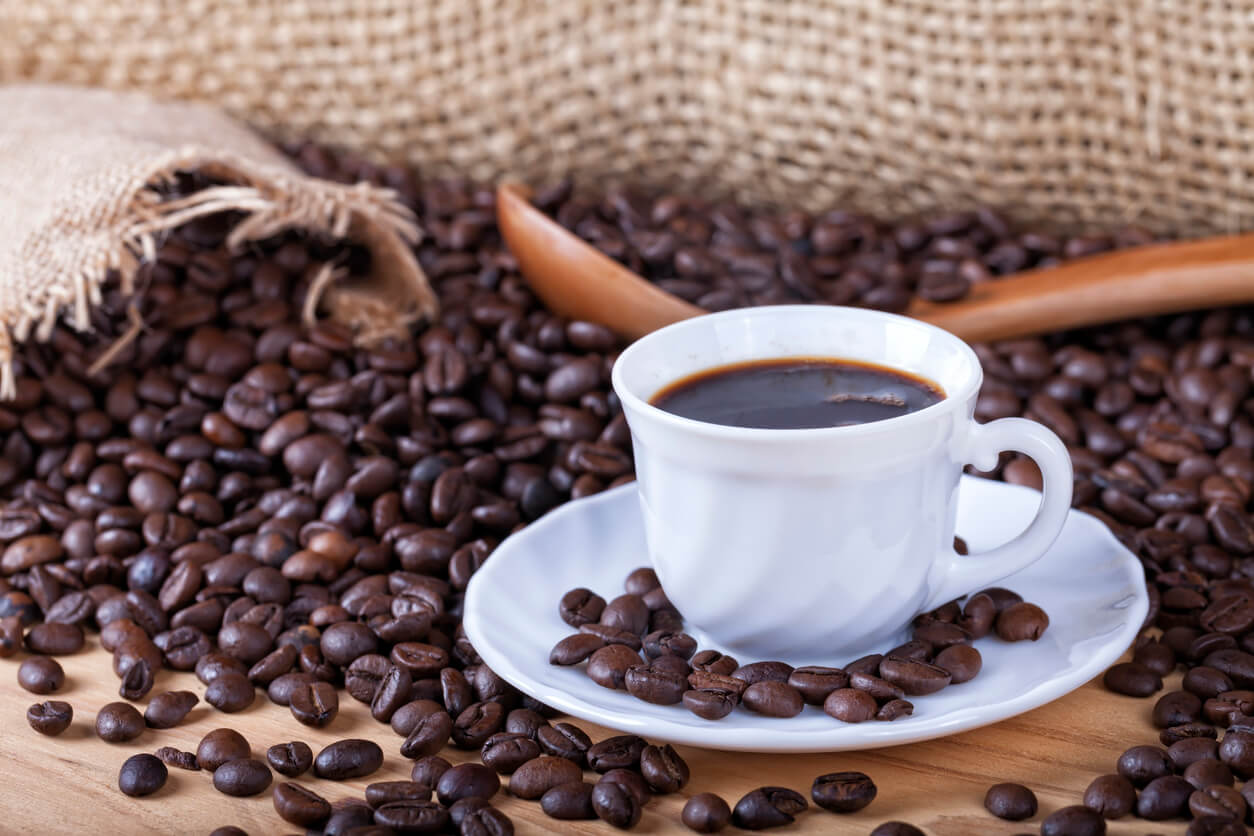 Une tasse de café avec des grains de café. 