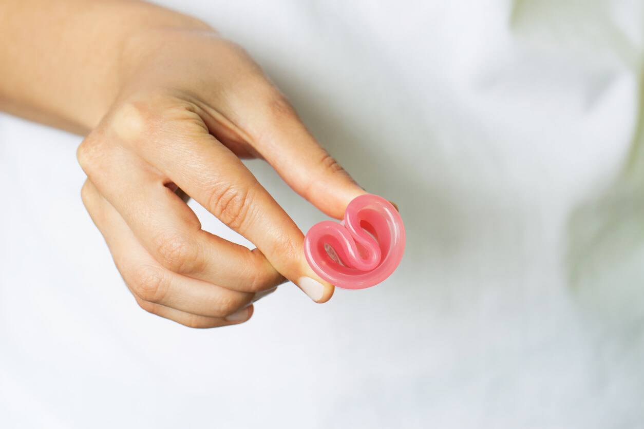 mujer adolescente coloca copa menstrual doblada silicona flexible 