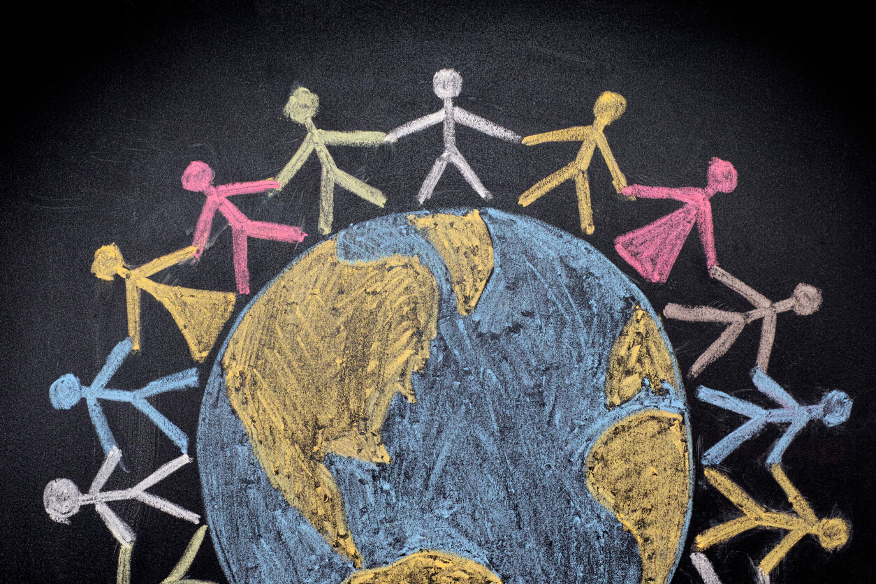 A chalkboard drawing of the world surrounded by stick figures holding hands.